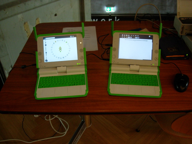 Two 'One Laptop per Child' OLPC XO-1 on a bench